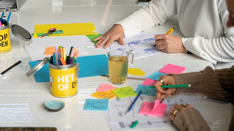 Een tafel waaraan mensen een workshop volgen.