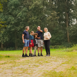 5 personen, waaronder twee kinderen in de natuur. 1 persoon wijst ergens naar. - Spannende outdoor escape in Drenthe Beleef het avontuur van je leven met de outdoor escape game "Drugslab op de berg"! Help de politie om een drugsbende te ontmaskeren door verborgen aanwijzingen te vinden en puzzels op te lossen in het bosrijke gebied van de Havelterberg. Dit unieke uitje is ideaal voor teambuilding of een leuk dagje uit met vrienden of familie.